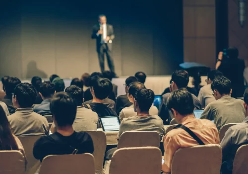 rear-side-audiences-sitting-listening-speackers